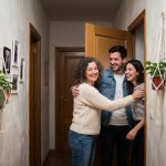 Femme accueillante saluant un couple dans un couloir
