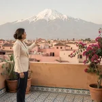 Agent immobilière sur une terrasse de Marrakech avec vue panoramique sur les montagnes de l'Atlas enneigées