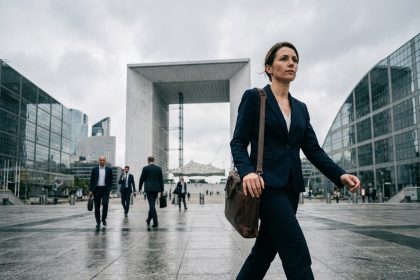Femme cadre marchant sur l'esplanade de La Défense avec la Grande Arche en arrière-plan