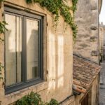 Fenêtre en aluminium anthracite installée sur une façade en pierre de taille rénovée à Nîmes
