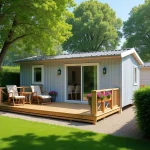 Mobil-home moderne installé sur une parcelle de terrain dans un parc résidentiel de loisirs en Vendée, avec terrasse en bois et jardin soigné