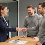 Agent immobilier remettant des clés à un couple lors de la signature d'une attestation de remise de clés