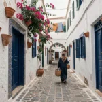 Ruelle pittoresque de la médina d'Essaouira avec portes bleues et femme en djellaba marchant vers une maison de charme